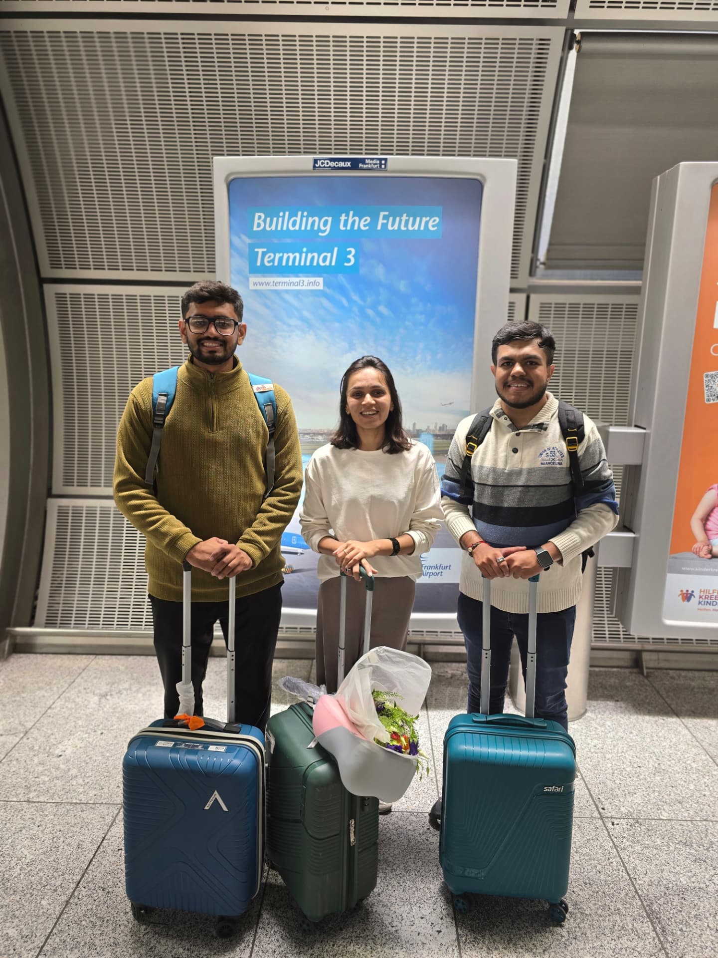 Three physiotherapists with luggage at Frankfurt Airport Terminal 3, ready to begin their German clinic roles